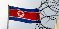 FILE PHOTO: A North Korea flag flutters next to concertina wire at the North Korean embassy in Kuala Lumpur