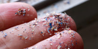 Close up side shot of microplastics lay on people hand.