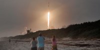 Image: Spectators watch a SpaceX Falcon 9 rocket carrying Starlink satellites launch from the Kennedy Space Center in Florida in 2020.