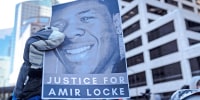 A demonstrator holds a photo of Amir Locke