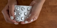A woman who self-managed her abortion holds a packet of misoprostol.