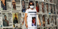 The mother of Osvaldo Javier Hernandez, who is missing, holds a sign with his photo during a demonstration to demand the government find him and other missing people at the Glorieta de Los Desaparecidos, Roundabout of the Disappeared, in Guadalajara, Jalisco state, Mexico, on May 10, 2022.