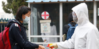 A schoolgirl has her hands disinfected before entering the Kumsong Secondary School No. 2 in Pyongyang, North Korea, on Nov. 3, 2021.