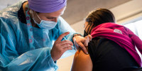 A health care worker administers a dose of the Pfizer-BioNTech Covid-19 vaccine on Feb. 11, 2022.