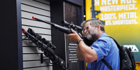 A visitor checks out a rifle at the annual NRA convention in Houston on May 27, 2022.
