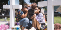 People visit a memorial for victims of the mass shooting at Robb Elementary School