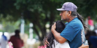 Families hug outside the SSGT Willie de Leon Civic Center