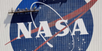 Workers on scaffolding repaint the NASA logo at the Kennedy Space Center in Cape Canaveral, Fla., on May 20, 2020.