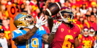 Kazmeir Allen #19 of the UCLA Bruins catches a pass and runs for a touchdown past Isaac Taylor-Stuart #6 of the USC Trojans in the first half of a NCAA football game in Los Angeles on Nov. 20, 2021.