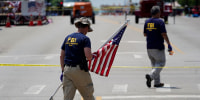Image: Members of the FBI's evidence response team investigate the scene of a mass shooting in Highland Park, Ill., on July 5, 2022.