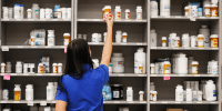 A pharmacy technician grabs a bottle of drugs off a shelf on Sept. 10, 2018, in Midvale, Utah.