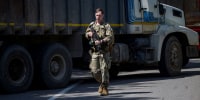 A US NATO soldier serving in Kosovo patrols next to a road barricade set up by ethnic Serbs near the town of Zubin Potok on Aug. 1, 2022.