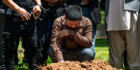 Altaf Hussain cries over the grave of his brother Aftab Hussein at Fairview Memorial Park in Albuquerque, N.M., on Aug. 5, 2022.