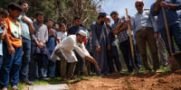 Image: People sprinkle dirt over the grave of Muhammad Afzaal Hussain, 27, at Fairview Memorial Park in Albuquerque, N.M., on Aug. 5, 2022.