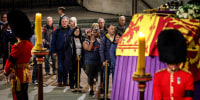 Image: Members of the public file past Queen Elizabeth II's flag-draped casket lying in state on the catafalque as they enter Westminster Hall in the middle of the night on Sept. 17, 2022 in London.