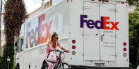 A bicyclist rides past a FedEx truck on Sept. 16, 2022 in Miami Beach, Fla.