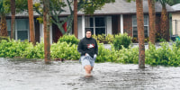 Wilfred Rosario walks in flood water