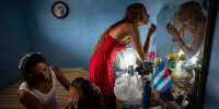 Liusba Grajales, left, puts makeup on her daughter Ainhoa as her partner Lisset Diaz Vallejo gets ready as they prepare to get married in Santa Clara, Cuba on Friday. The couple, which has been together for seven years, is one of the first to make the decision to get legally married in Cuba following the new Family Code, which opened up everything from equal marriage to surrogate mothers.