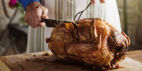 Man carving fresh roasted turkey at home