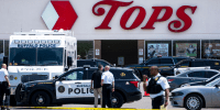 Law enforcement officials work at the scene of a mass shooting at Tops Friendly Market