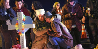People visit a makeshift memorial near the Club Q nightclub on Nov. 21, 2022 in Colorado Springs, Colo.g