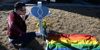 A mourner at a cross for Daniel Aston at a memorial for the victims of the Club Q shooting, in Colorado Springs, Colo., on Monday.
