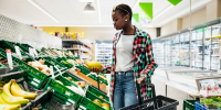 Young Woman Shopping For Fruit At Supermarket