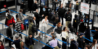 Travelers wait to go through security at O'Hare International Airport in Chicago on Nov. 23, 2022.