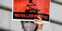 A woman protests the use of robots by the San Francisco Police Department outside of City Hall on Dec. 5, 2022.