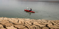 A kayaker fishes in Lake Oroville as water levels remain low due to continuing drought conditions in Oroville, Calif., on Aug. 22, 2021.