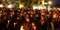 Mourners hold candles during a candlelight vigil for the victims of the recent mass shooting in Half Moon Bay. Calif.