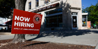 A "Now Hiring" sign is displayed in front of a Chipotle restaurant  in Washington