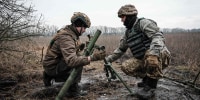 Ukrainian soldiers adjust a 60mm mortar tube near the frontline in the Donetsk region on Jan. 31, 2023. 
