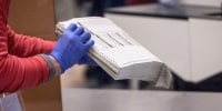 Election workers sort ballots at the Maricopa County Tabulation and Election Center in Phoenix