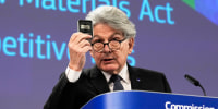 Thierry Breton holds up raw materials during a media conference at EU headquarters