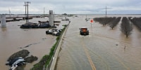 A truck drives across a flooded road near Corcoran, Calif.