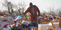 A resident looks through the piles of debris at a mobile home park in Rolling Fork, Miss