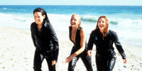 Cameron Diaz, Drew Barrymore and Lucy Liu walking up the sand of a beach in a scene from the film 'Charlie's Angels', 2000. 