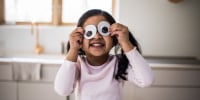 Young girl playing with silly googly eyes at home