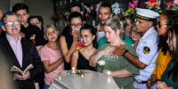 Image: Bruno Machado, right, and his wife Neide Cunha, center, mourn at the funeral of their five-year-old son Bernardo who was killed by a man with a hatchet inside a day care center, at the Sao Jose cemetery in Blumenau, Santa Catarina state, Brazil, on April 6, 2023. 