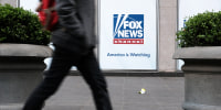People walk by the News Corporation headquarters, home to Fox News, on April 18, 2023 in New York City. Moments before opening arguments were set to begin this afternoon, Fox News and Dominion Voting Systems said that they had reached a settlement of $787 million in the voting machine company's defamation lawsuit against Fox.
