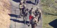 Jack Teixeira is taken into custody by armed tactical agents on April 13, 2023, in Dighton, Mass. 