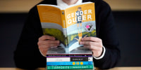 Amanda Darrow, directora de programas juveniles, familiares y educativos del Utah Pride Center, posa con libros que han sido objeto de quejas por parte de los padres, el 16 de diciembre de 2021 en Salt Lake City.