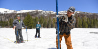 Sean de Guzman of the California Department of Water Resources inserts a snow depth survey pole into the snow in El Dorado County, Calif., on May 1, 2023.