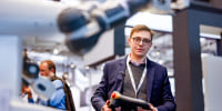 Philip Singer operates a robot developed by HPE and AI startup Aleph Alpha at a technology fair 