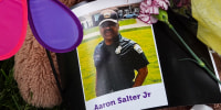 Flowers, candles and mementoes are left in honor Aaron Salter Jr., the hero security guard who was shot and killed trying to stop a gunman at the Tops supermarket, in Buffalo, N.Y., on May 18, 2022.
