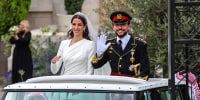 Image: Jordan's Crown Prince Hussein and his wife Saudi Rajwa al-Seif wave as they leave the Zahran Palace in Amman on June 1, 2023 following their royal wedding ceremony. 