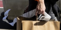 A shopper holds onto a receipt in New York on March 22, 2023.