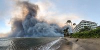 Smoke billows near Lahaina as wildfires driven by high winds destroy a large part of the historic town of Lahaina, Hawaii, on Aug. 9, 2023.