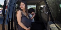 Tanisha Edison, who is four days away from having a baby, sits in a truck. She and her family members drove from Hay River to the St. Albert, Alta. evacuee center to escape the wildfires on Wednesday, Aug. 16, 2023.